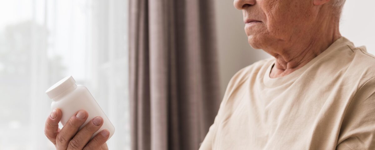 idoso segurando frasco de suplemento